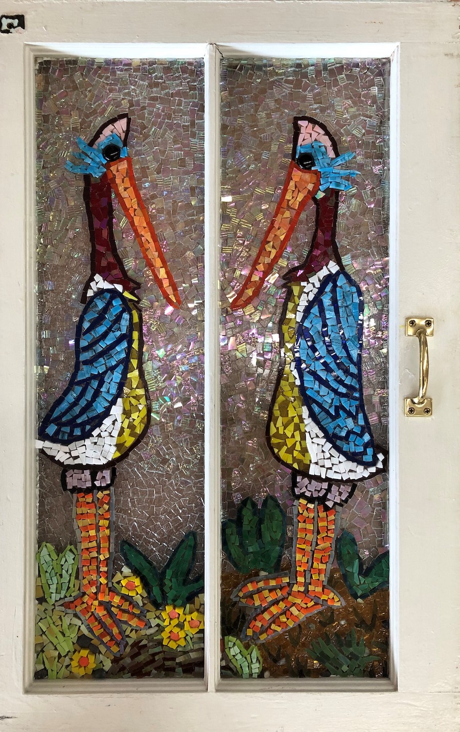A mosaic of two colorful birds, with long features, facing each other.